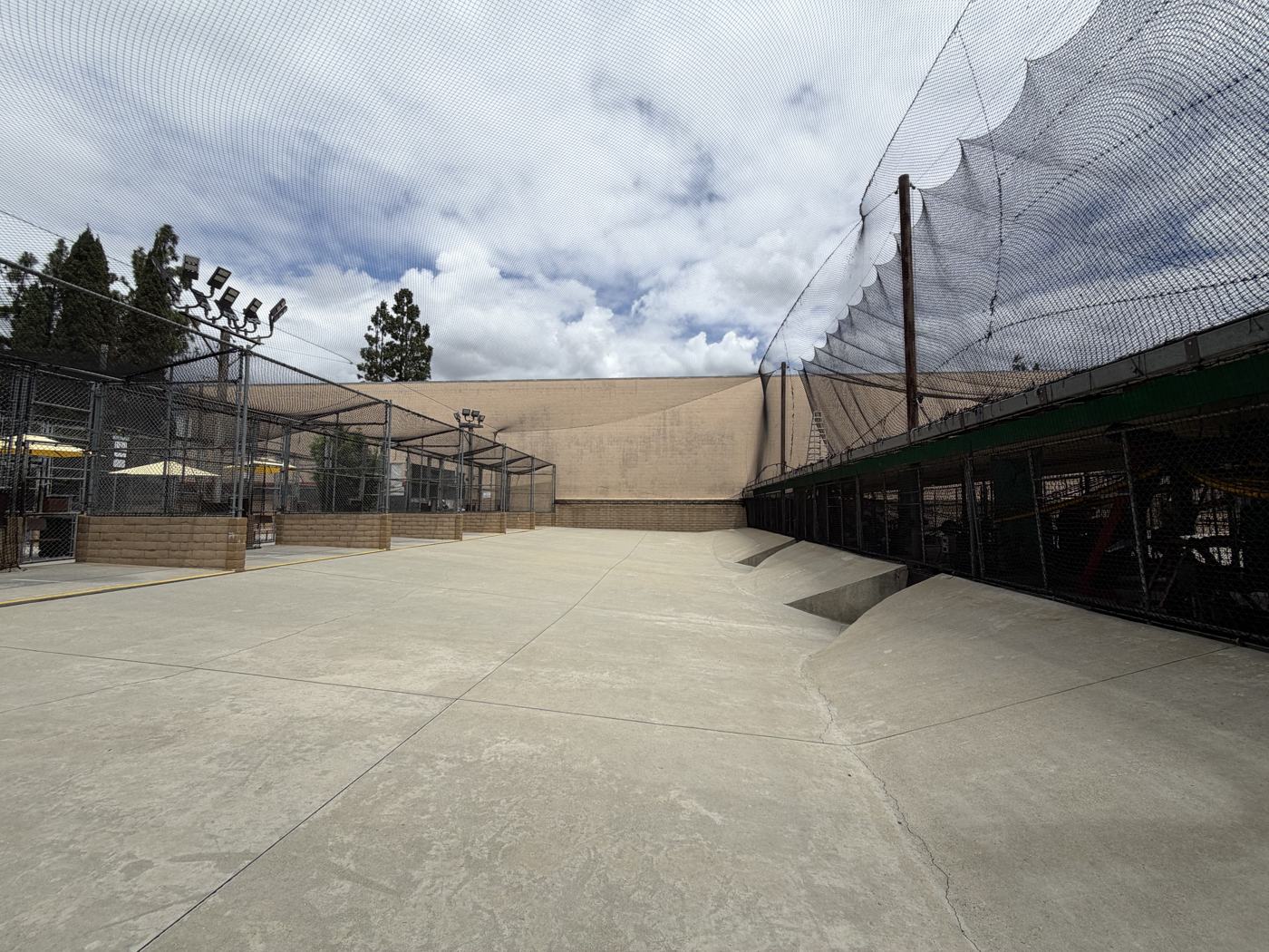 Home Run Park's wide-open outdoor batting cages with 30-foot netting against the sky in Anaheim