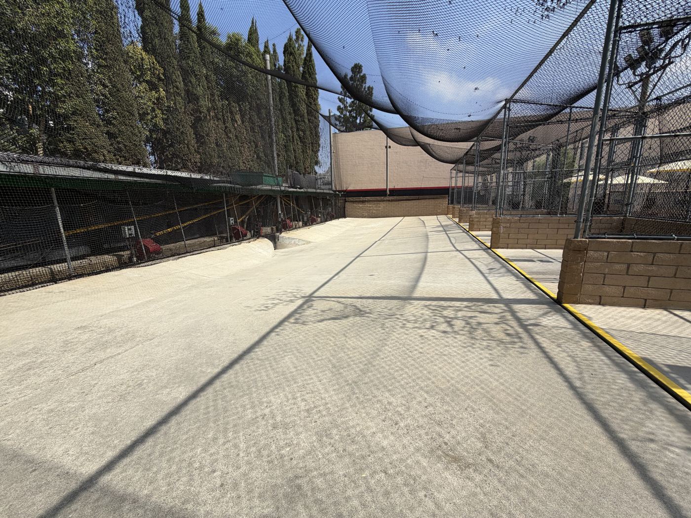 Wide-open concrete lanes under the tall net canopy